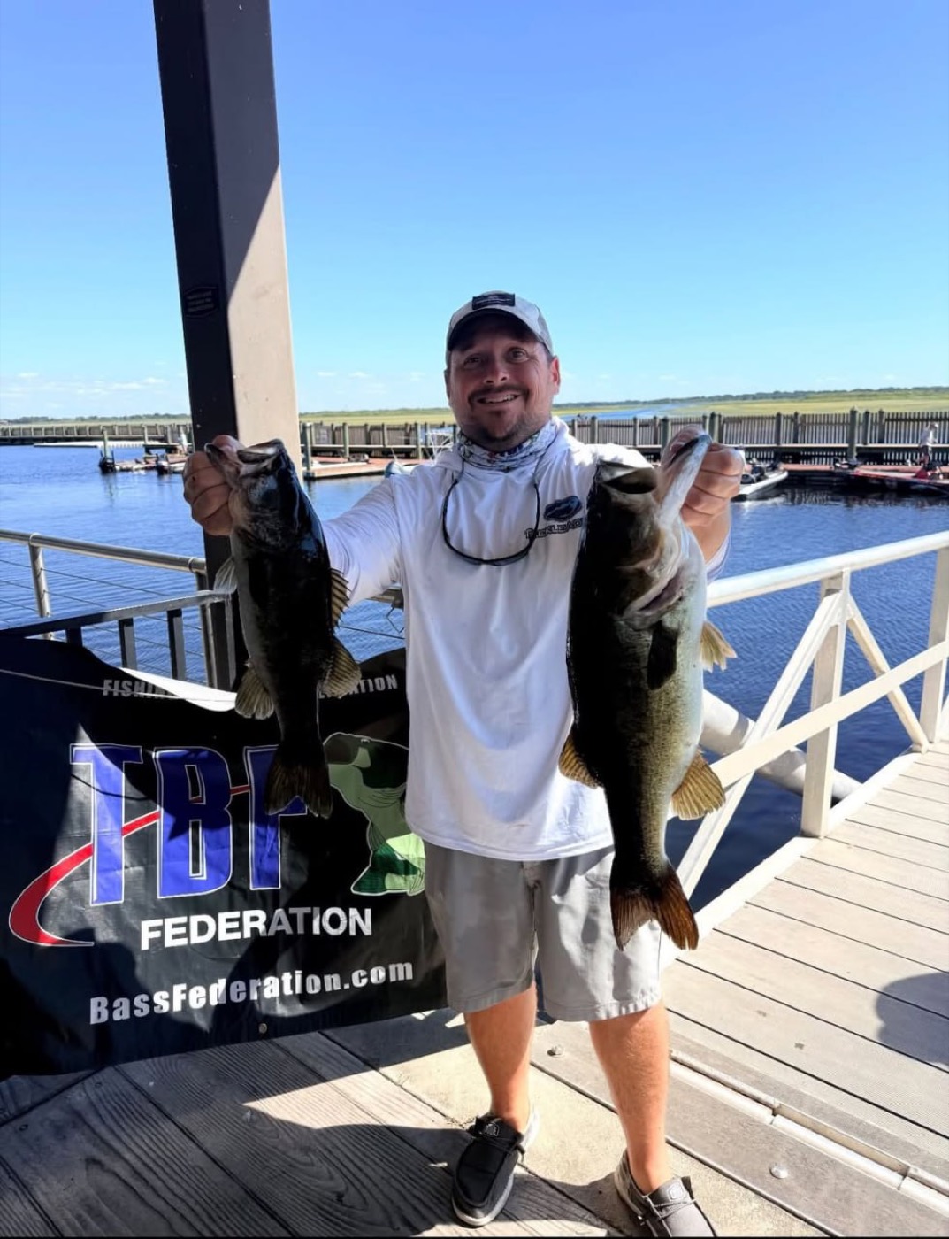 Angler holding two bass at a tournament weigh-in